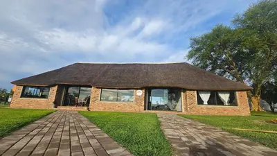 a small brick house with a thatched roof at Die Pekanneut in Polokwane