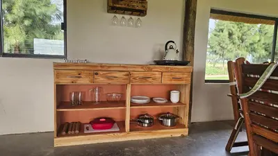 a wooden cabinet in a kitchen with pots and pans at Die Pekanneut in Polokwane