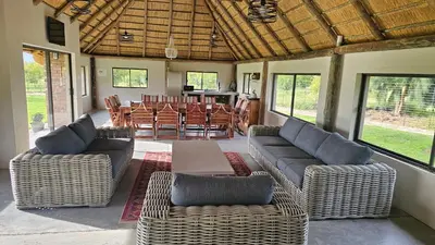 a living room with couches and a table and chairs at Die Pekanneut in Polokwane