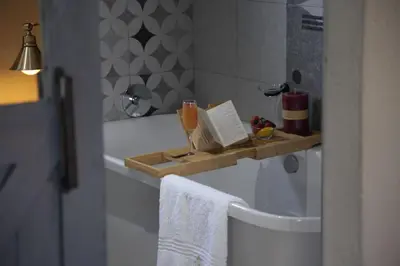 a bathroom with a bath tub with a book on a shelf at The Village GuestHouse in Acornhoek