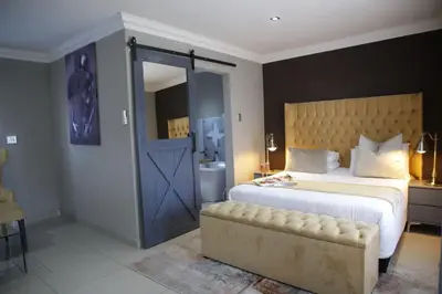 a bedroom with a large bed with a blue door at The Village GuestHouse in Acornhoek