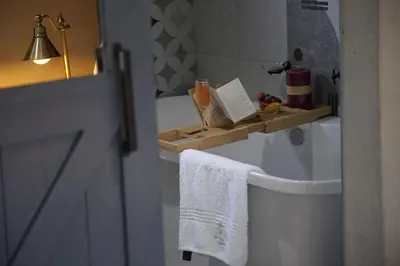 a bathroom with a towel rack on the back of a toilet at The Village GuestHouse in Acornhoek
