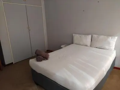 a white bed with a teddy bear sitting on top of it at Lynnwood 246 House in Pretoria