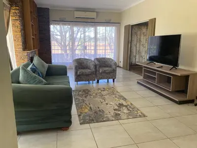 a living room with a couch and a flat screen tv at Lynnwood 246 House in Pretoria