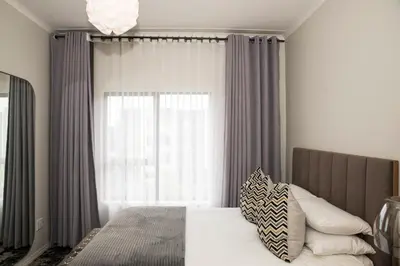 a bedroom with a bed with a large window at Eirini Elegant Aphrodite Apartment in Midrand
