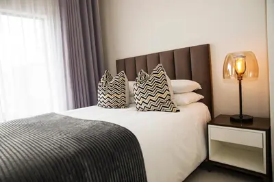 a bedroom with a bed with pillows on it at Eirini Elegant Aphrodite Apartment in Midrand