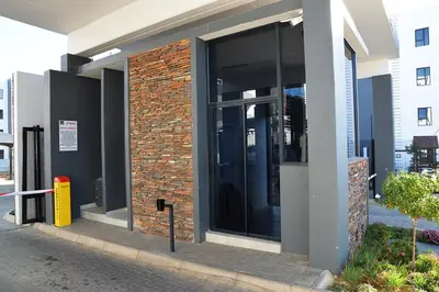 a building with glass doors on the side of it at Eirini Elegant Aphrodite Apartment in Midrand