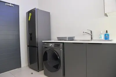 a kitchen with a refrigerator and a washing machine at Eirini Elegant Aphrodite Apartment in Midrand