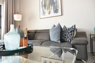 a living room with a couch and a table at Eirini Elegant Aphrodite Apartment in Midrand