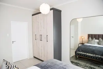 a bedroom with a large mirror and a bed at Eirini Elegant Aphrodite Apartment in Midrand