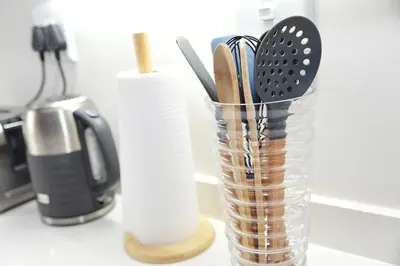 a glass container filled with kitchen utensils on a counter at Eirini Elegant Aphrodite Apartment in Midrand