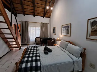 a bedroom with a bed and a table in a room at Thaba Bolayi Private Nature Reserve in Musina