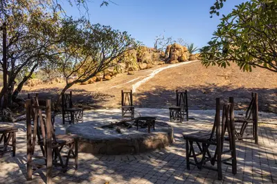 a group of wooden chairs and tables in a field at Thaba Bolayi Private Nature Reserve in Musina