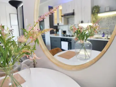 a mirror and vases with flowers on a table at Eirini Elegant Hades Apartment in Midrand