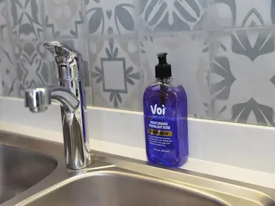a bottle of violet soap sitting on top of a sink at Eirini Elegant Hades Apartment in Midrand