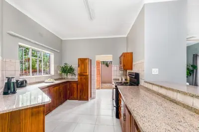 a large kitchen with wooden cabinets and counter tops at Spurflower in Tzaneen