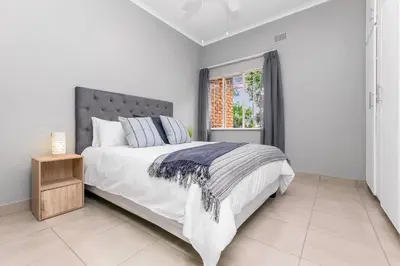 a bedroom with a large bed and a window at Spurflower in Tzaneen