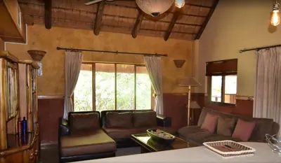 a living room with a couch and a table at Golf View Guest House in Musina
