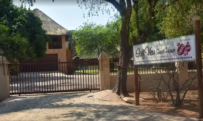 a gate with a sign in front of a house at Golf View Guest House in Musina