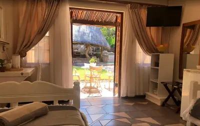 a bedroom with a bed and a door to a patio at Golf View Guest House in Musina
