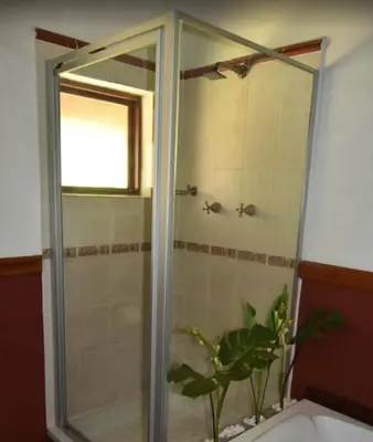 a shower with a glass door in a bathroom at Golf View Guest House in Musina