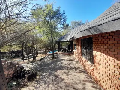 a brick building with a fence next to a playground at 2694 Marloth Park Family Villa in Marloth Park