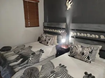 a room with two beds with zebra pillows on them at 2694 Marloth Park Family Villa in Marloth Park