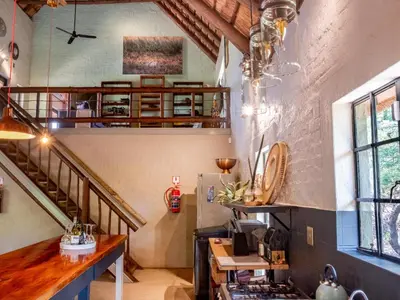 a kitchen with a spiral staircase in a house at Croc Orvyll's Kruger Lodge in Marloth Park