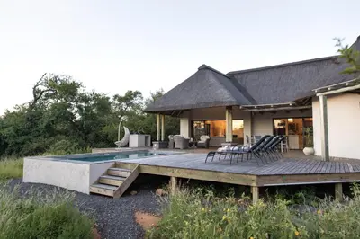 a house with a deck and a swimming pool at Villa Blaaskans in Hoedspruit