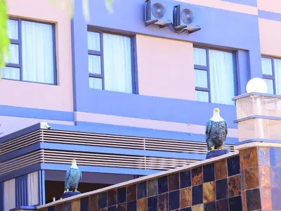 two birds sitting on the ledge of a building at The Empire Hotel in Vendaland