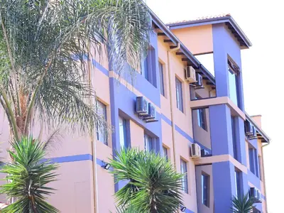 a building with palm trees in front of it at The Empire Hotel in Vendaland