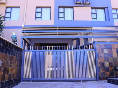 a blue fence in front of a house at The Empire Hotel in Vendaland