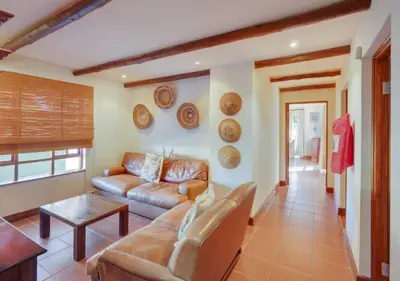 a living room with a couch and a table at Zebula 1 Pela Lodge, 4-bedroom house in Warmbaths