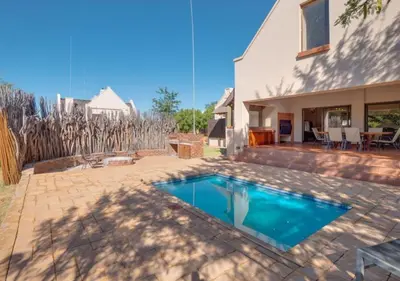 a swimming pool in the backyard of a house at Zebula 1 Pela Lodge, 4-bedroom house in Warmbaths