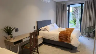 a bedroom with a bed and a desk and a desk at GrootBoom Guest Rooms in Pretoria