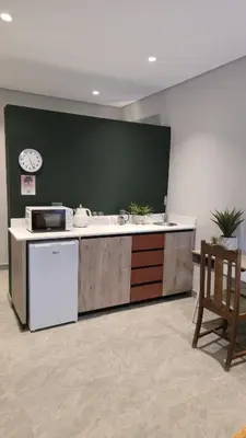 a kitchen with a counter with a sink and a refrigerator at GrootBoom Guest Rooms in Pretoria