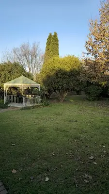 a gazebo in the middle of a grass field at GrootBoom Guest Rooms in Pretoria
