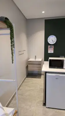 a kitchen with a counter and a clock on the wall at Grootboom Guest Rooms in Pretoria