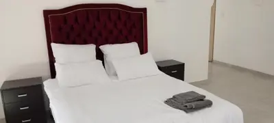 a bedroom with a bed with white sheets and pillows at Villa paradiso 1 in Centurion
