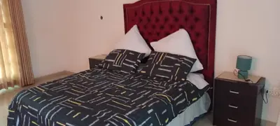 a bedroom with a bed with a red headboard and pillows at Villa paradiso 1 in Centurion