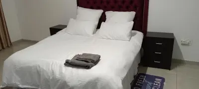 a white bed with a pile of towels on it at Villa paradiso 1 in Centurion