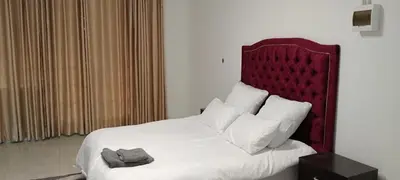 a bedroom with a large bed with a red headboard at Villa paradiso 1 in Centurion