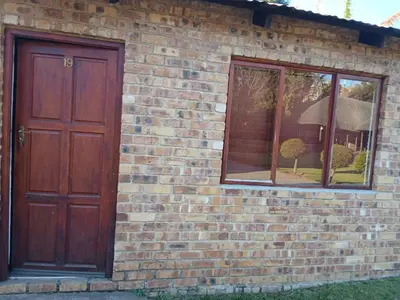 a brick building with a door and a window at Aero Ensuites- OR Tambo in Kempton Park
