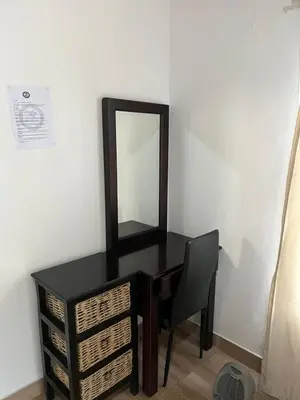 a black desk with a mirror and a chair at Aero Ensuites- OR Tambo in Kempton Park