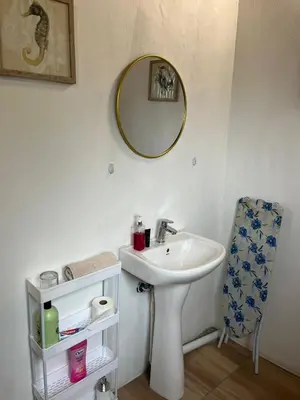a bathroom with a sink and a mirror and a chair at Aero Ensuites- OR Tambo in Kempton Park
