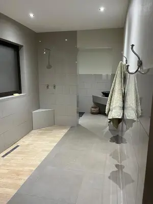 a bathroom with a shower and towels on a wall at Imberbe Private Lodge in Hectorspruit