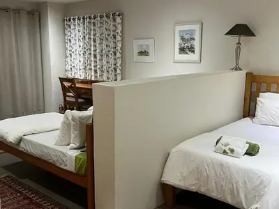a hotel room with two beds and a table at Imberbe Private Lodge in Hectorspruit