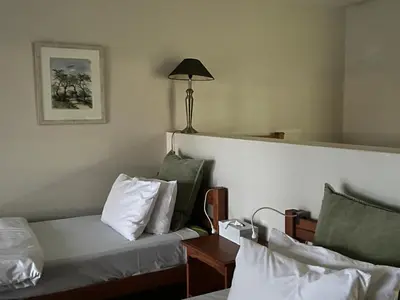 a hotel room with a bed and a table with a lamp at Imberbe Private Lodge in Hectorspruit