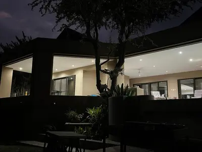 a house lit up at night with tables and chairs at Imberbe Private Lodge in Hectorspruit