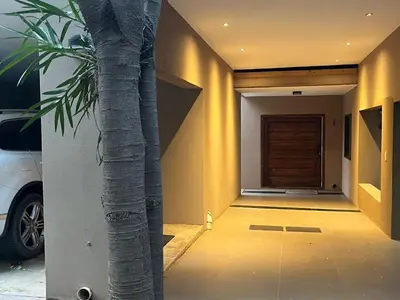 a palm tree in front of a house with a door at Imberbe Private Lodge in Hectorspruit